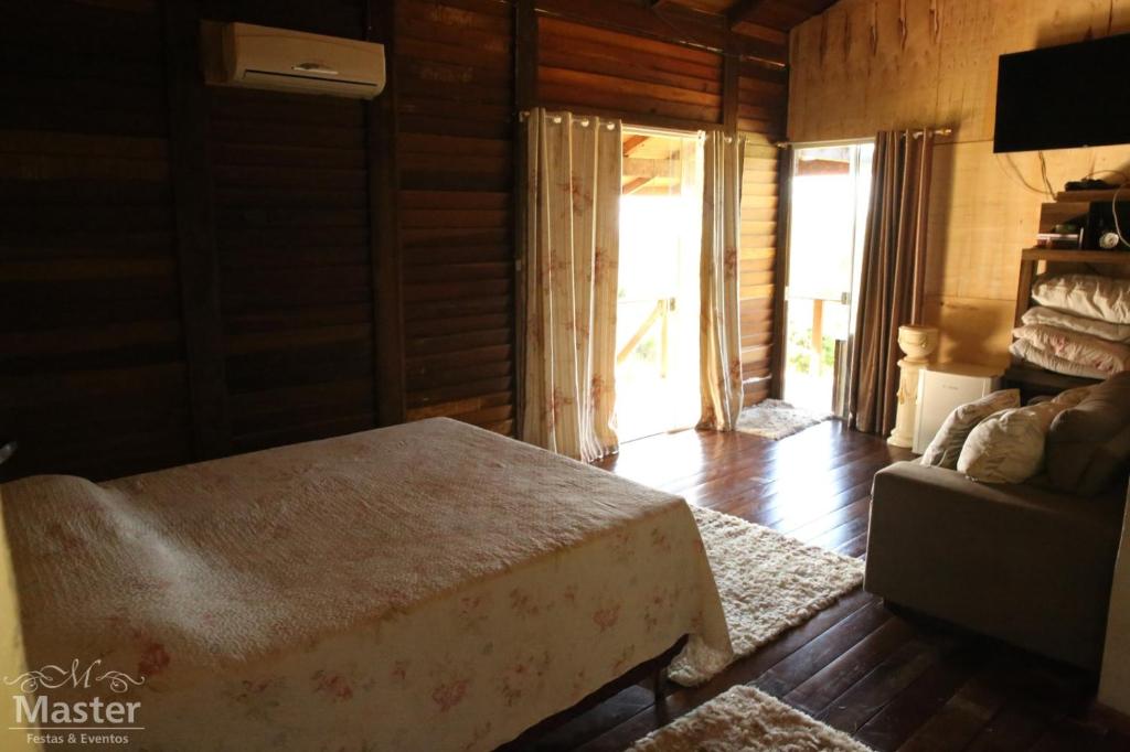 巴拉那瓜Pousada nascente das aguas的一间卧室配有一张床和一张沙发