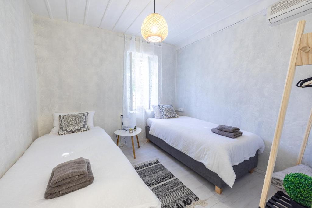 纳夫普利翁Theros Cottage Nafplio的一间卧室配有两张床和吊灯。