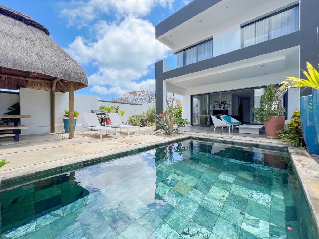 格兰贝伊Résidence Celestial - Premium 3 bedrooms Villa with volcanic stone Pool的一座带游泳池和房子的别墅