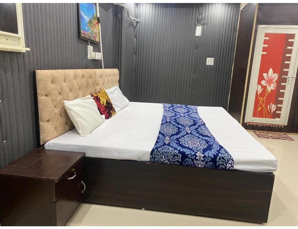 占西Hotel Subh Ratri, Jhansi的一间卧室配有一张带蓝白色毯子的床