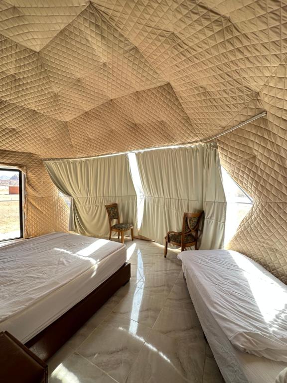 瓦迪拉姆Wadi rum camp的一间帐篷内带两张床的卧室
