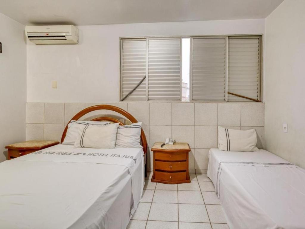 戈亚尼亚Itajubá Classic Hotel Goiânia的一间卧室设有两张床和窗户。