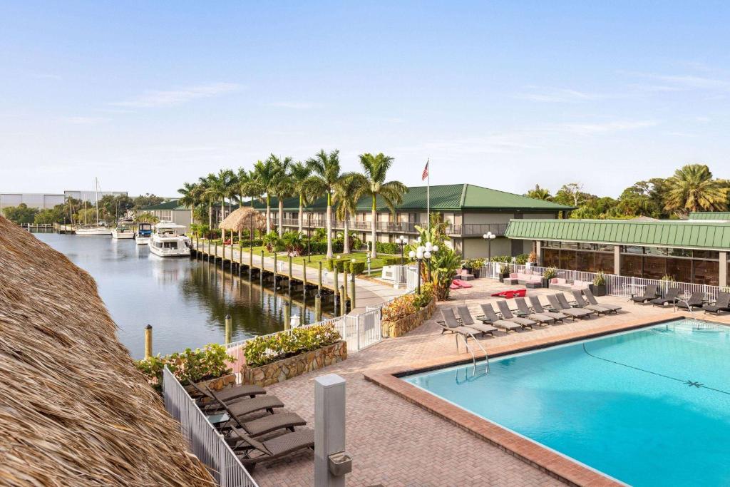 萨拉索塔Ramada by Wyndham Sarasota Waterfront的享有带码头的度假村的游泳池景致