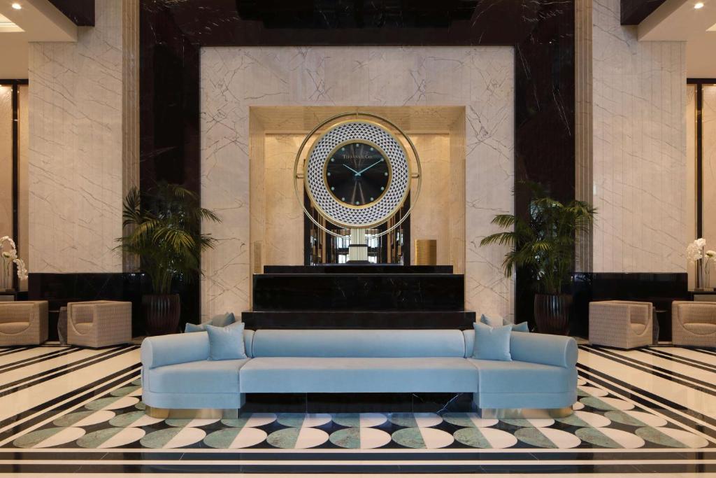 多哈Waldorf Astoria Doha West Bay的大堂的蓝色沙发,带时钟