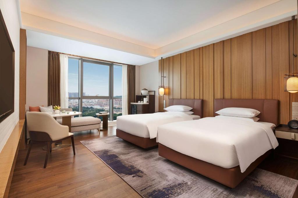 广州广州增城凯悦酒店的酒店客房配有两张床和一张书桌