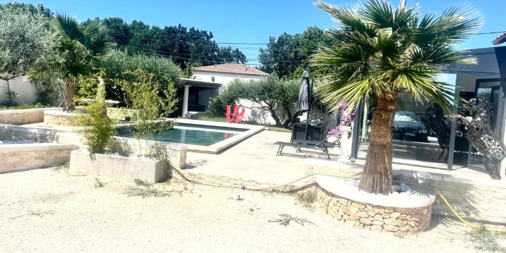 Montaren-et-Saint-MédiersHavre de paix的棕榈树在一座带游泳池的房子前