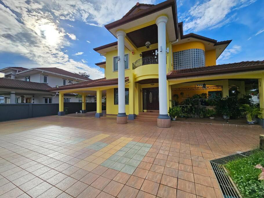 古晋Lovely Luxury Detached House Vivacity Kuching的大型黄色房屋,设有大型车道