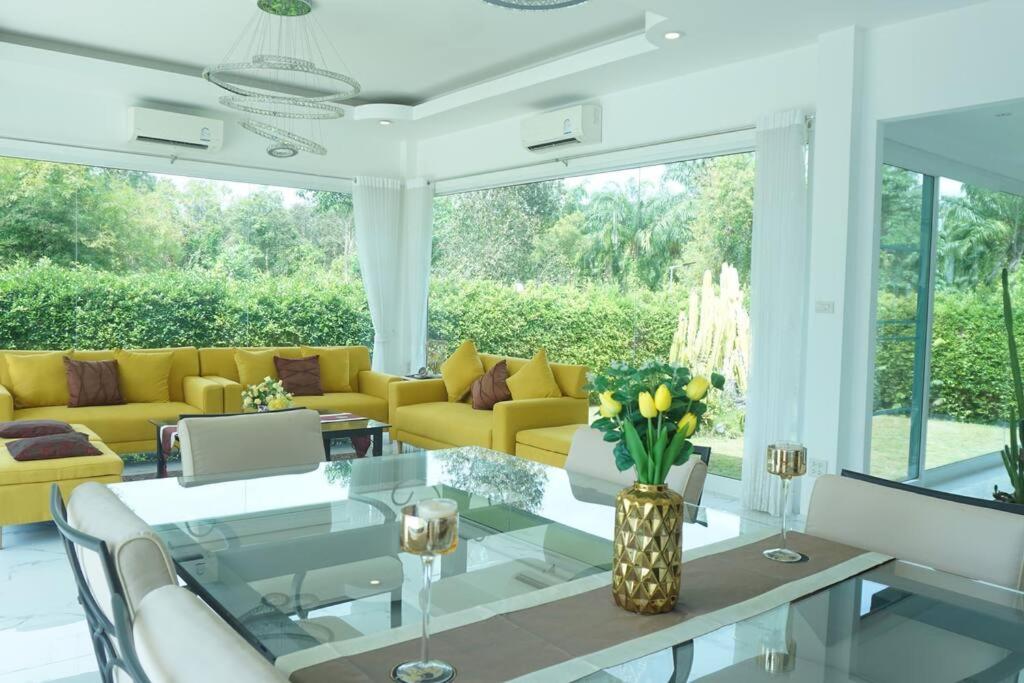 春蓬CoaSea Pool Villa - 3 Bedrooms 3.5 Bathrooms的客厅配有黄色家具和玻璃桌