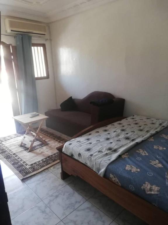 达喀尔Buzsahm的一间卧室配有一张床和一个沙发