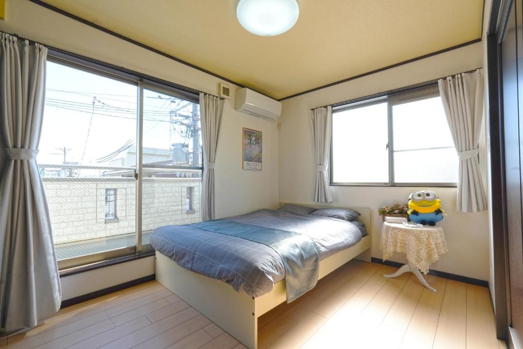 大阪Maple Hotel Osaka的一间卧室设有一张床和两个大窗户