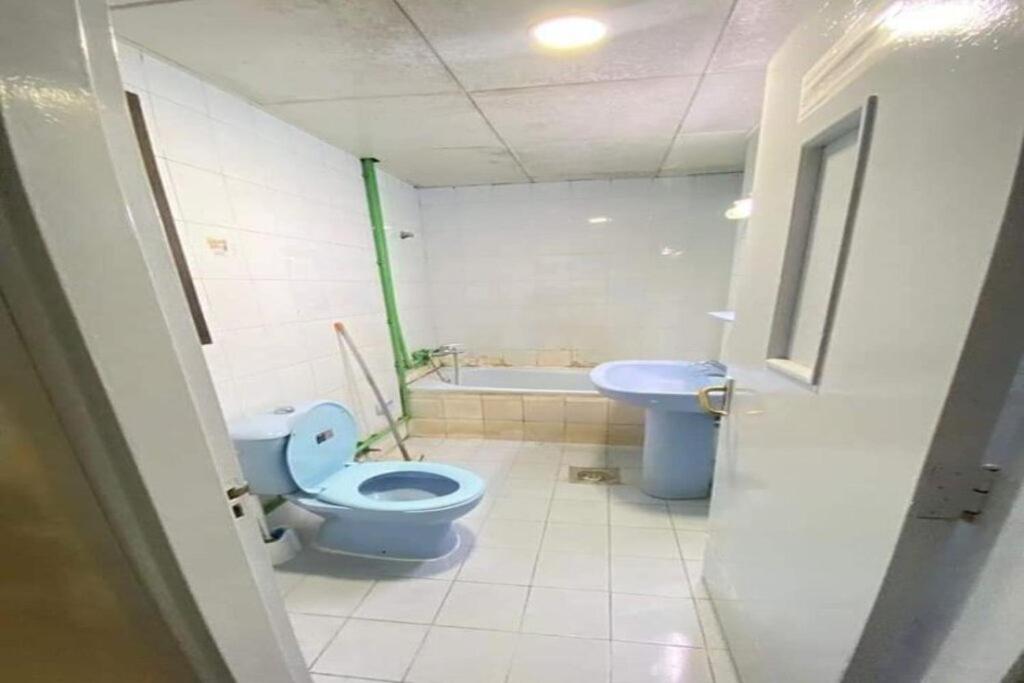 阿布扎比Single Room Near "World Trade Centre&Beach" Abudhabi的浴室设有蓝色的卫生间和水槽。