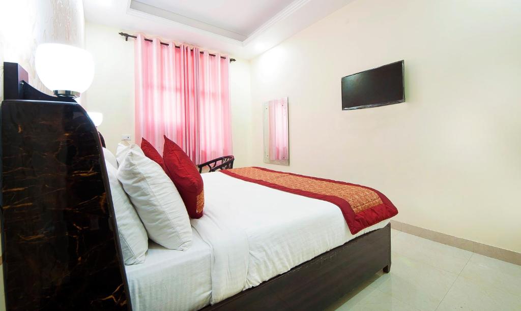 新德里Hotel Jiva Banquet的卧室配有一张床铺,墙上配有电视