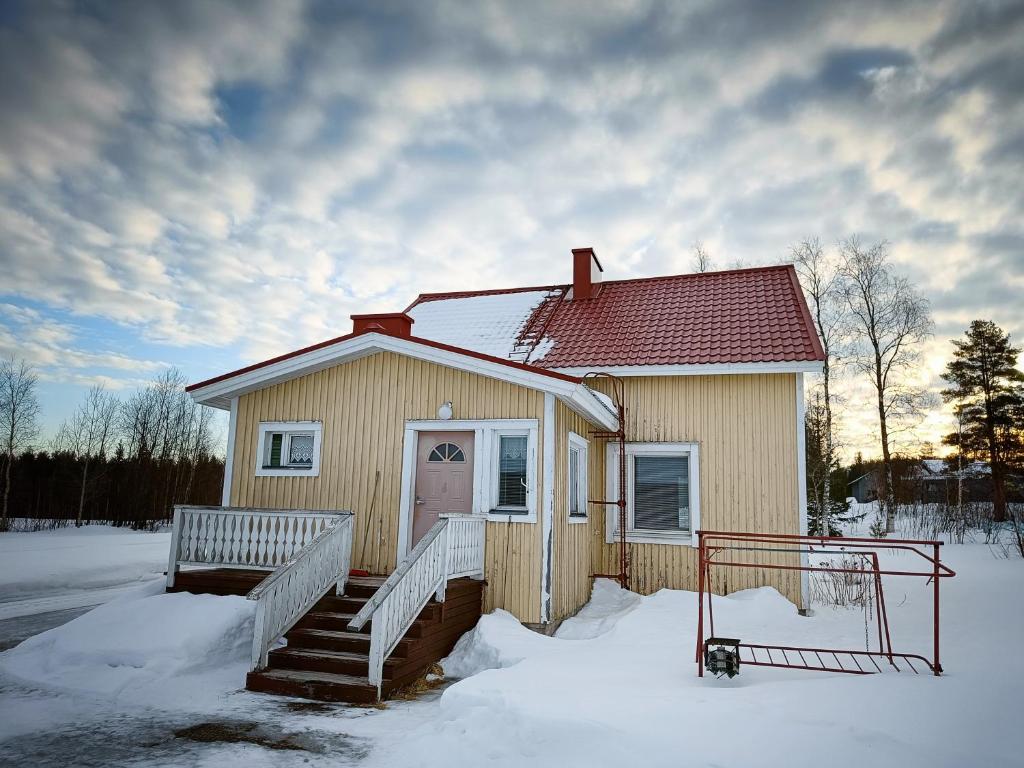 YlitornioMäki-mummola的雪中的小房子,有楼梯