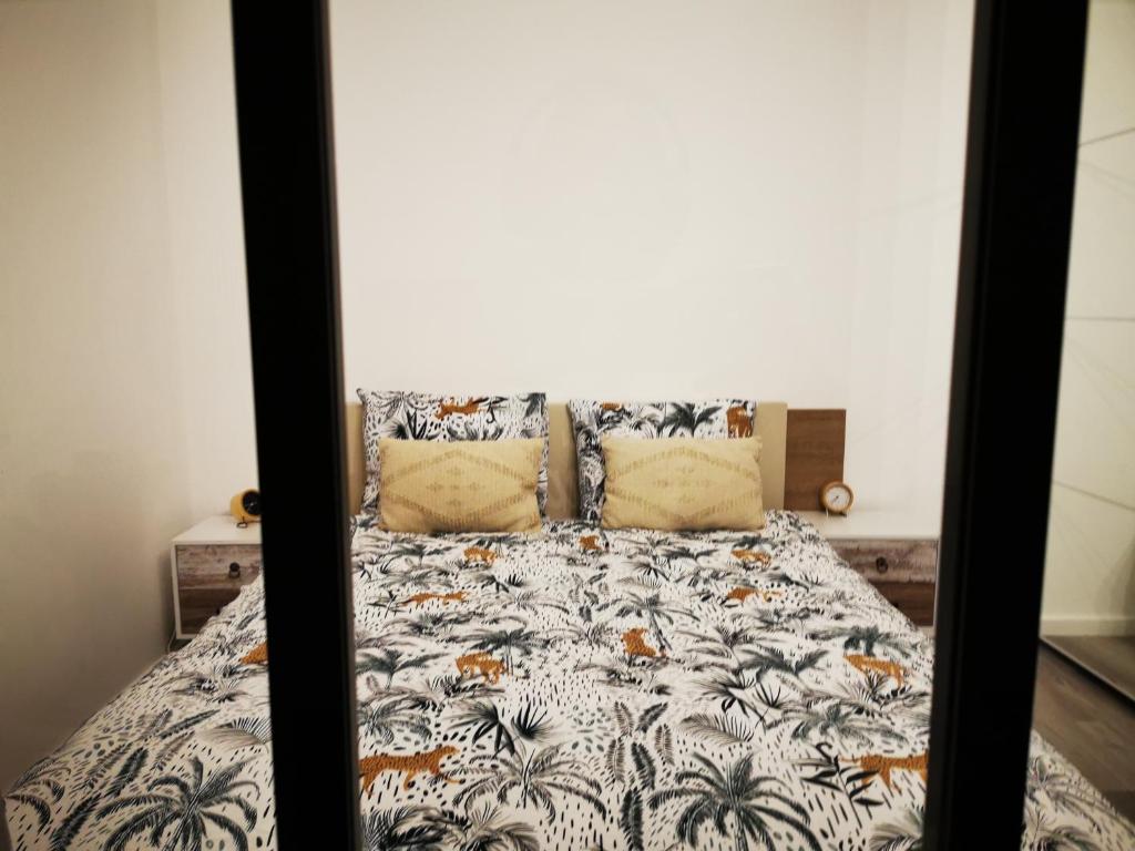 阿尔泽特河畔埃施AtHome - Appart-hotel with private parking的一间卧室配有一张带棕榈树床罩的床。