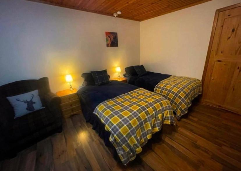 UlstaSea View B & B的一间卧室配有两张床、一张沙发和两盏灯。