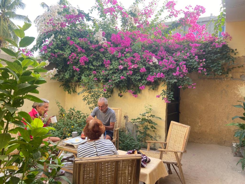 圣路易斯Le Poulagou的一群人坐在花园里的桌子上,种着鲜花