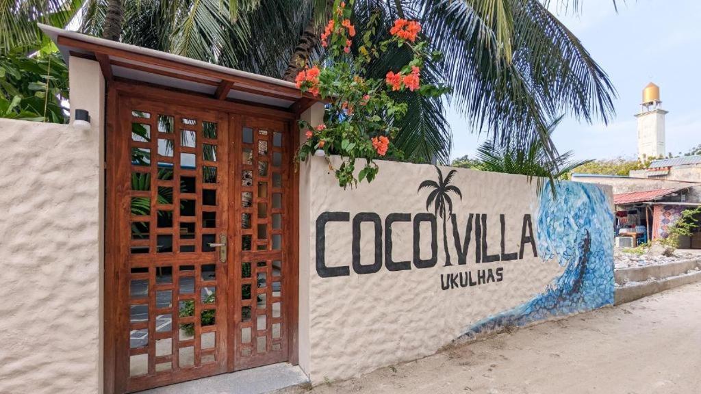 乌库拉斯Coco Villa Ukulhas的墙上有木门,上面有标志