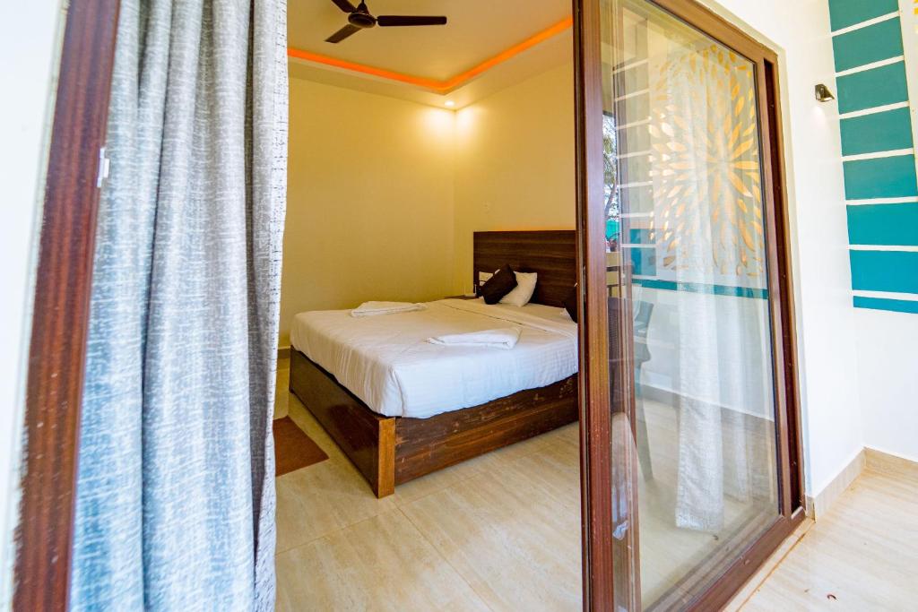 阿贡达Darsy Residency的一间小卧室,配有一张床和镜子
