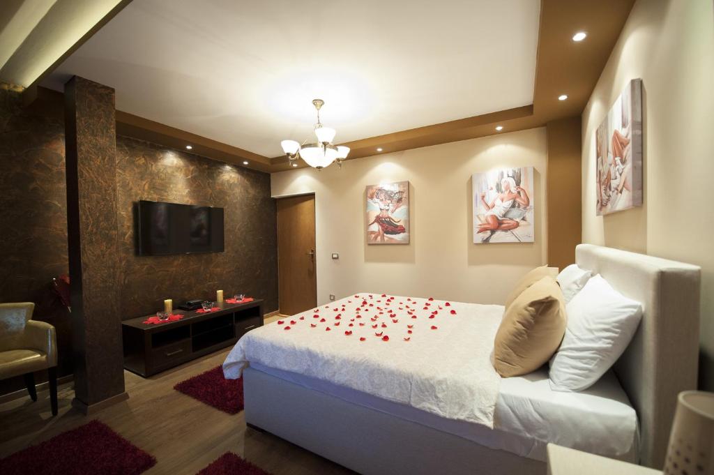 采蒂涅Benvenuti Apartments的一间卧室,床上铺有红色玫瑰花瓣