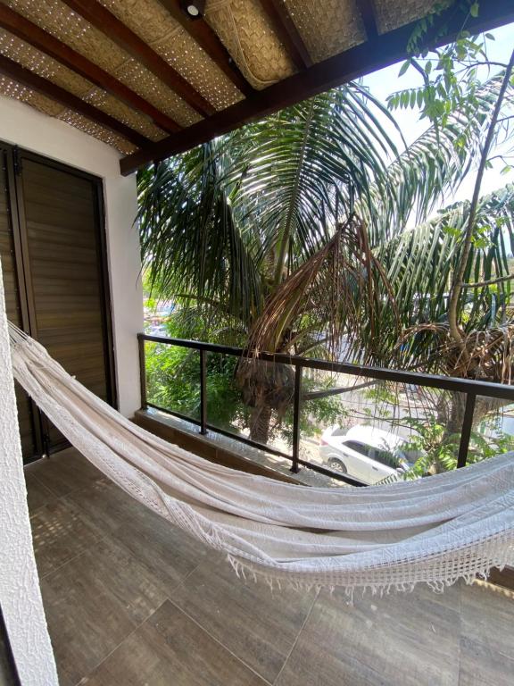 阿拉亚尔-杜卡布Casa Amora的棕榈树房子里的吊床