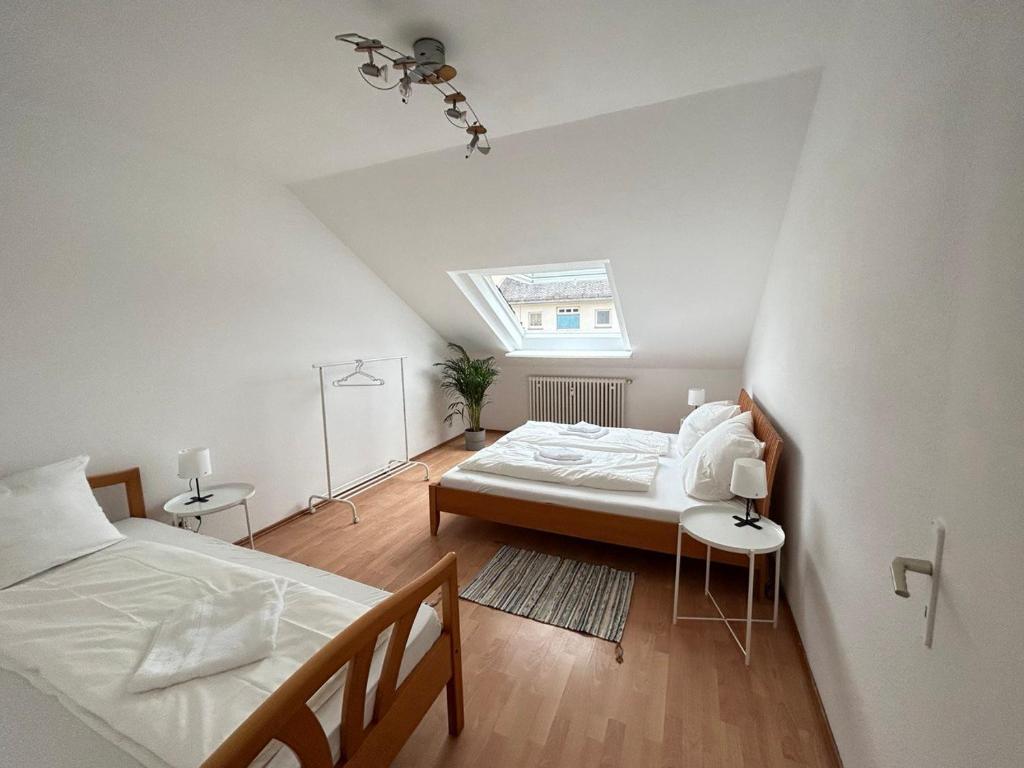 美因河畔法兰克福GardenApartment的阁楼卧室设有两张床和窗户。