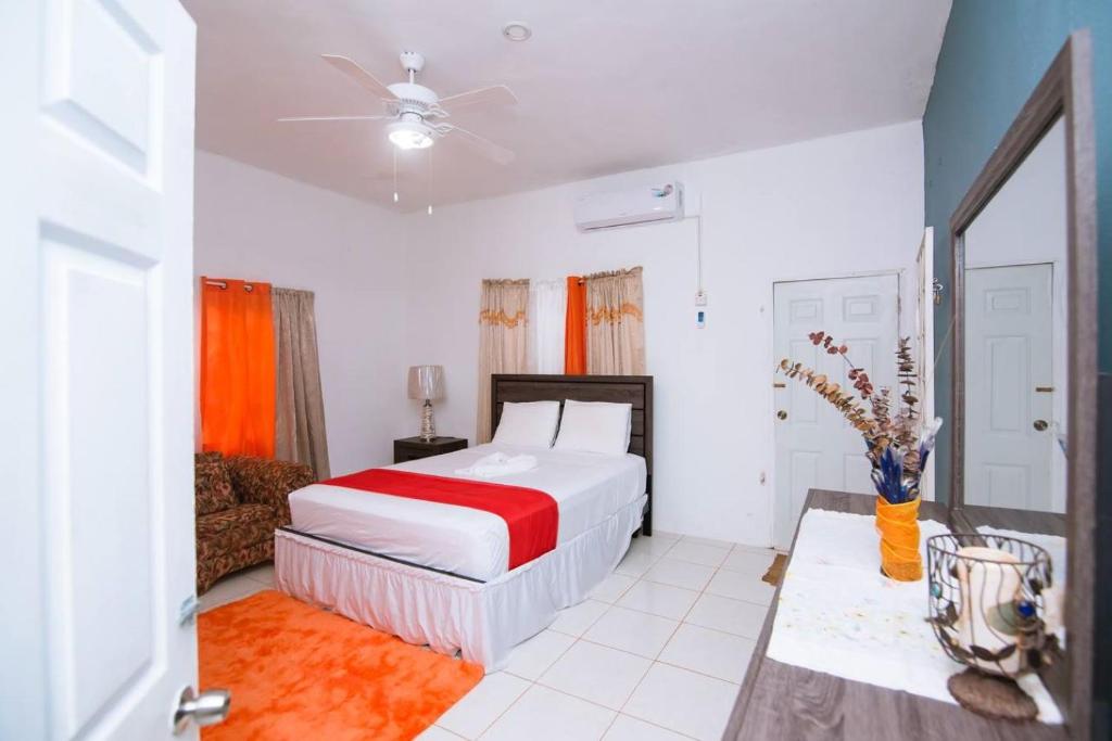 圣玛丽Suzette Guesthouse Accommodations的一间卧室配有一张带红色和白色床罩的床。