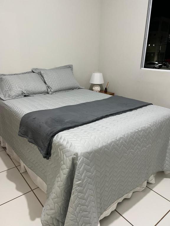 加拉尼温斯Temporada 101的白色卧室,配有一张带灰色毯子的床