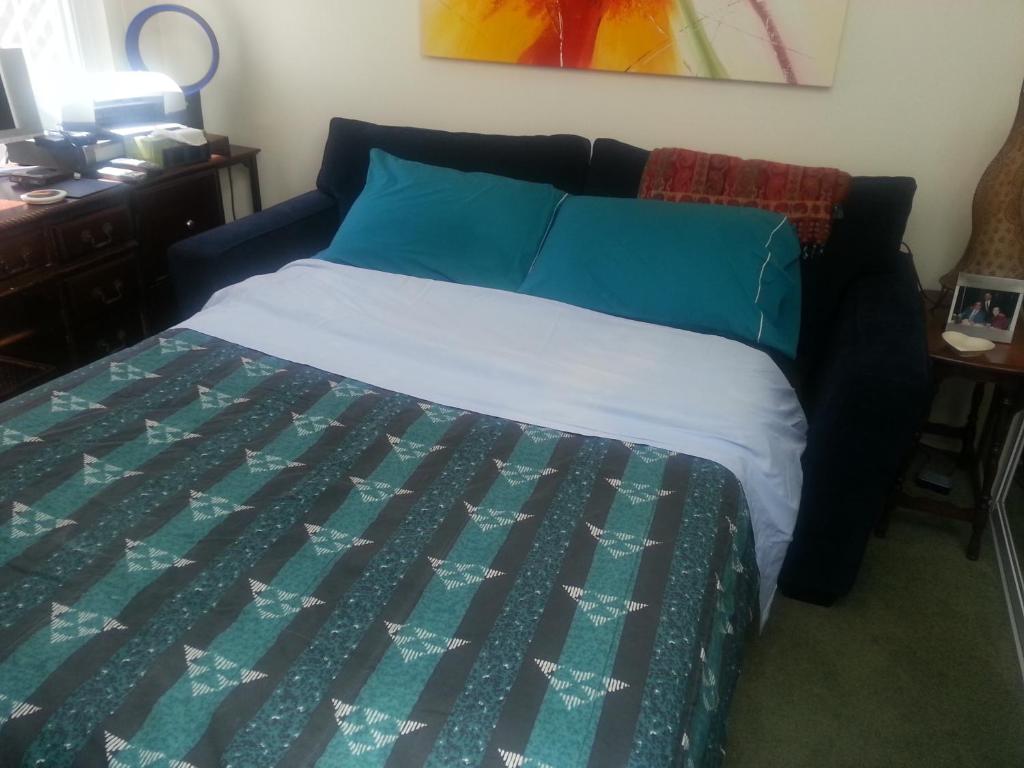 旧金山Centrally located; Walk anywhere!的一间卧室配有一张带蓝色和绿色被子的床