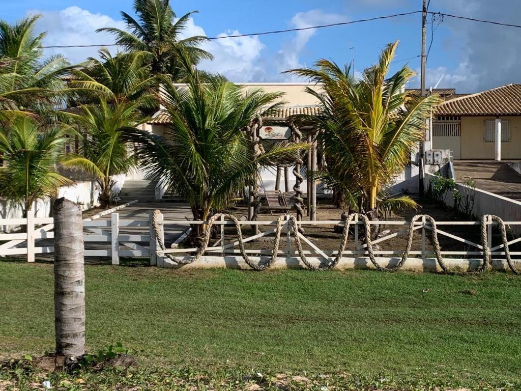 巴拉杜斯科凯鲁斯Casa de Praia - Aracaju - Jatobá的棕榈树屋前的围栏