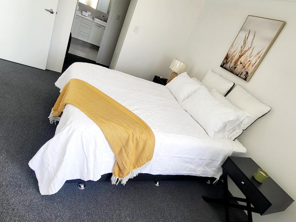 亨利布鲁克Comfort oasis family getaway的卧室配有一张带白色床单和枕头的大床。