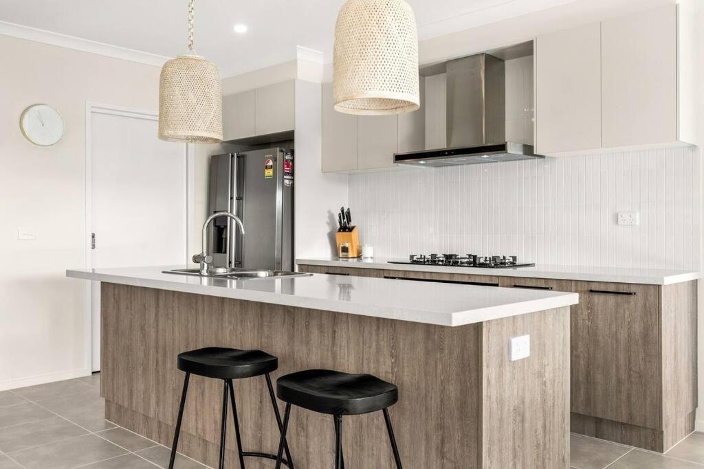 圣雷莫Elsa Remo - Stylish Ultra modern的厨房在厨房柜台设有两张凳子