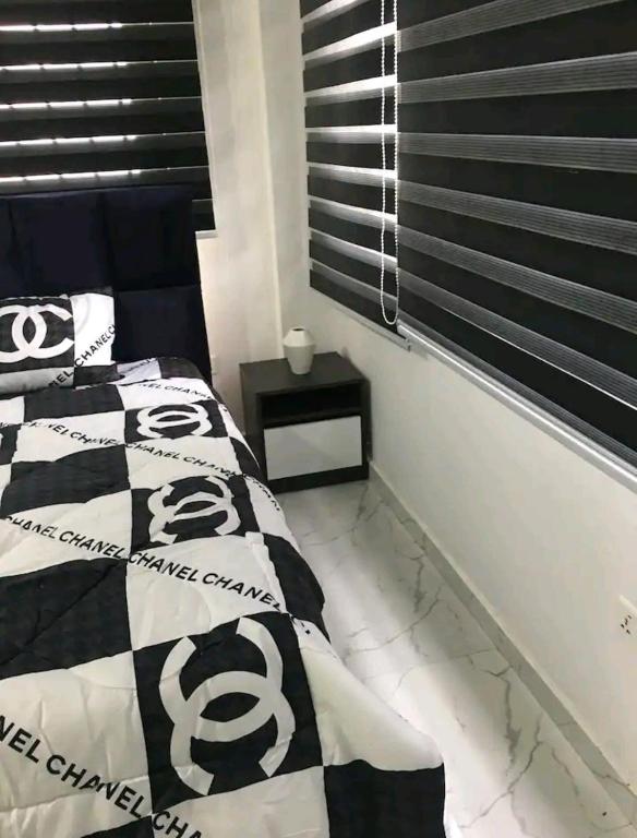 HanyaAjay's residence的一间卧室配有一张带黑白色棉被的床