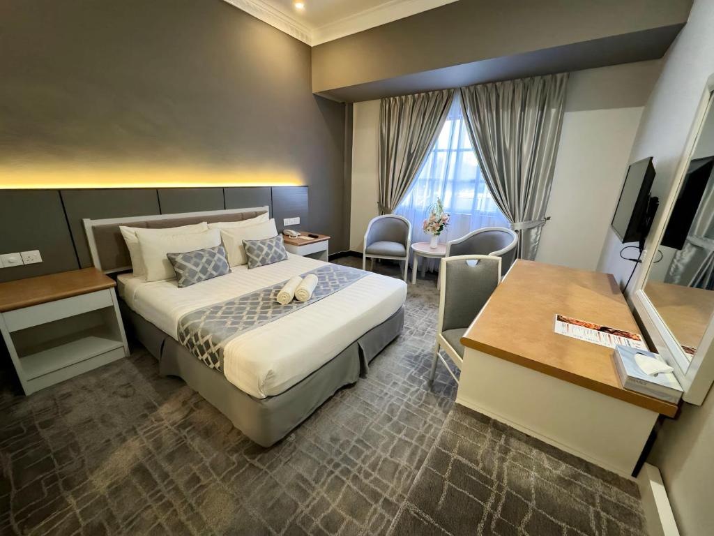 瓜拉丁加奴瓜拉丁加奴迷人酒店的配有一张床和一张书桌的酒店客房