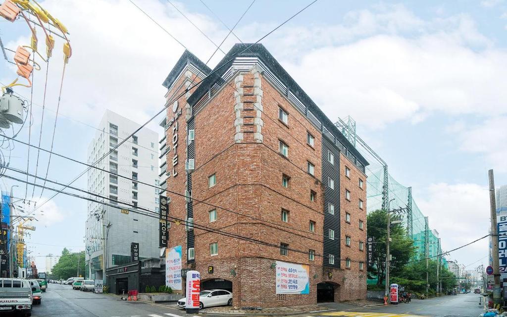 水原市24 Block Hotel的城市街道上一座高大的砖砌建筑