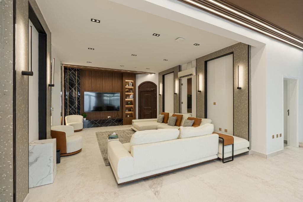 多哈La Maison Resort的客厅配有白色沙发和电视