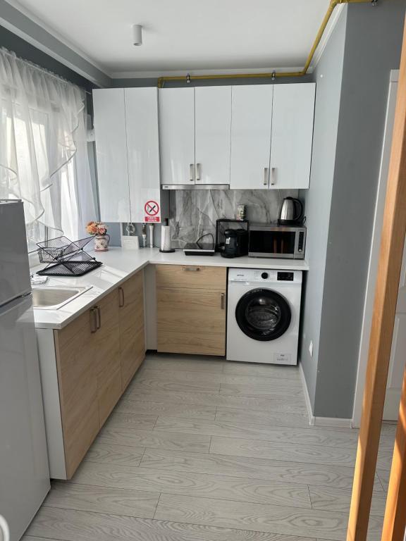 奥内什蒂Studio Home的厨房配有白色橱柜和洗衣机。