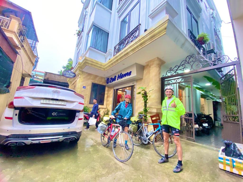 宁平O Zoli Home的两个人站在一辆汽车旁边,骑着自行车