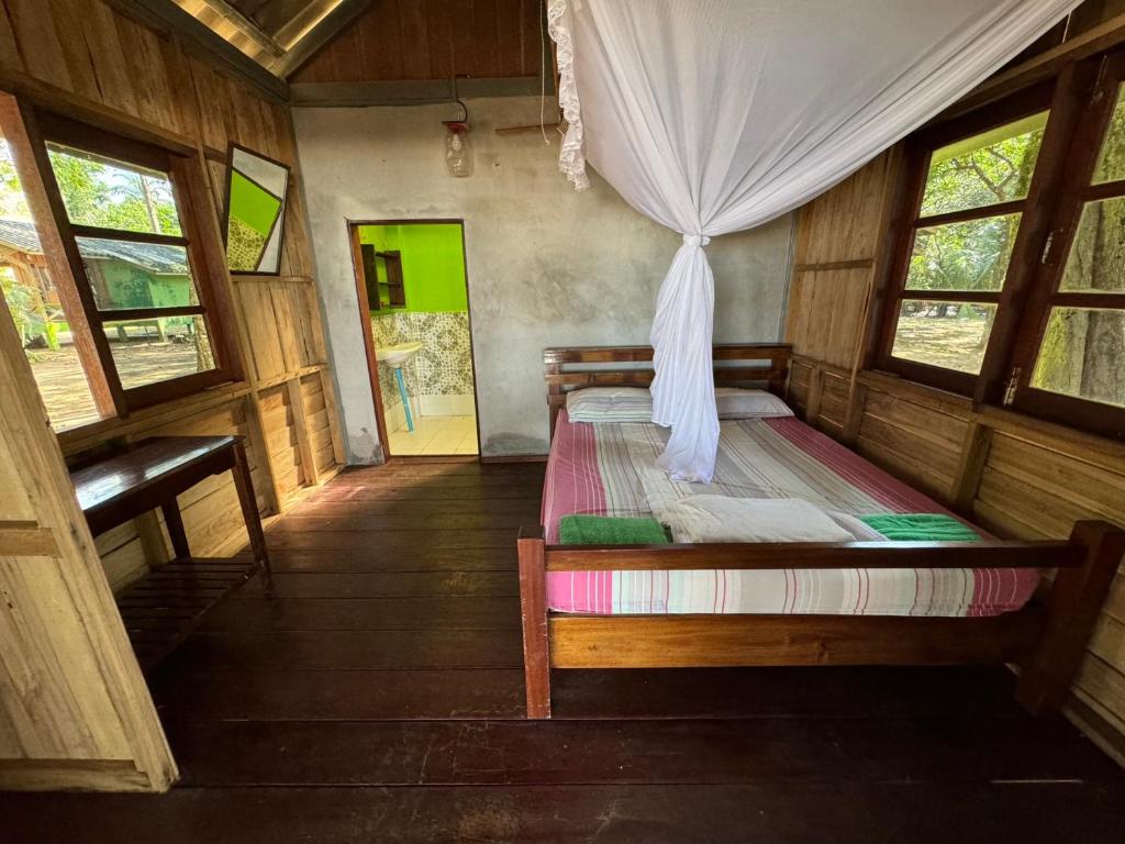 昌岛Changthong Bungalow的一间设有床铺的卧室,位于带窗户的房间内