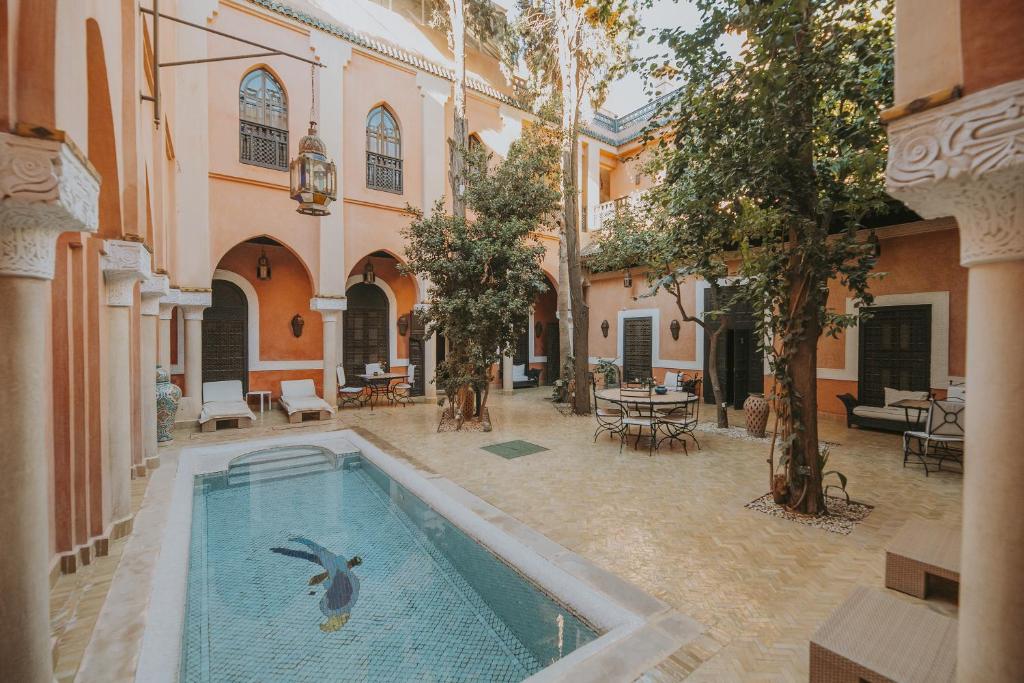 马拉喀什佩洛特布鲁套房及Spa摩洛哥传统庭院住宅的庭院里的游泳池,水中鸟