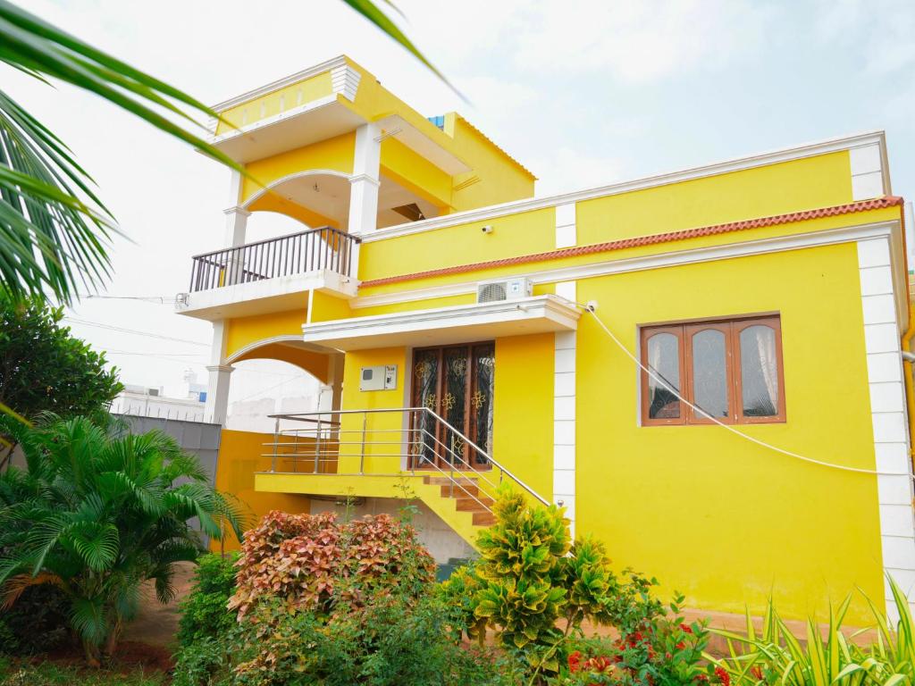 蓬蒂切里Prabas - Farm house的带阳台的黄色房屋