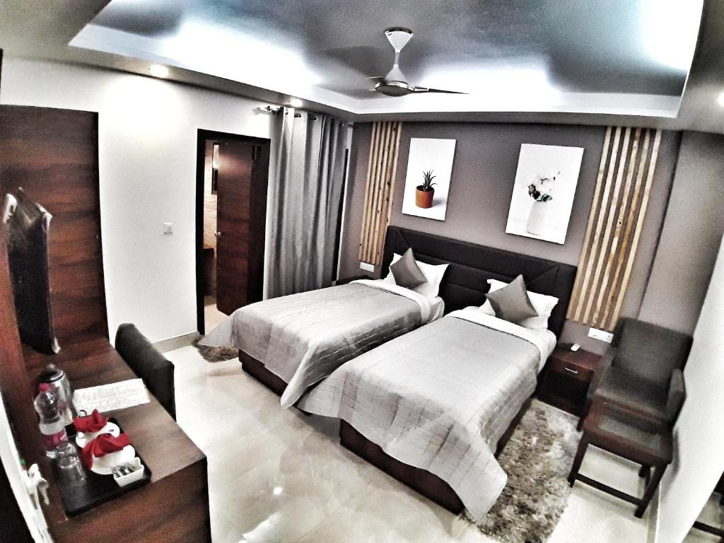 新德里Airport Hotel Delhi Aerocity的一间卧室配有两张床和椅子