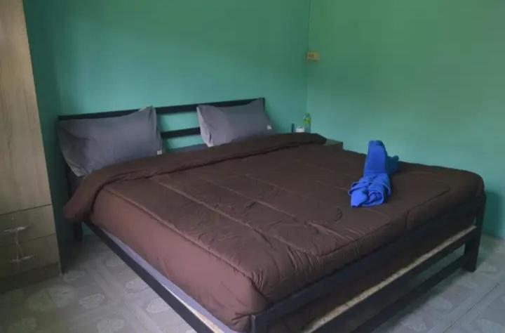 Khlaung Phai BaeThe Lion House的卧室内的一张大床,卧室内有蓝色的墙壁