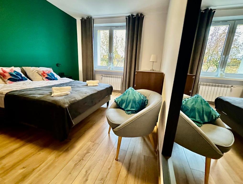 琴斯托霍瓦Jazz Apartament Częstochowa Centrum 2-bedroom的一间卧室配有一张床、两把椅子和一张沙发