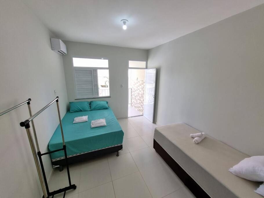阿拉卡茹Casa 2/4 para temporada的一间卧室设有两张床和窗户。