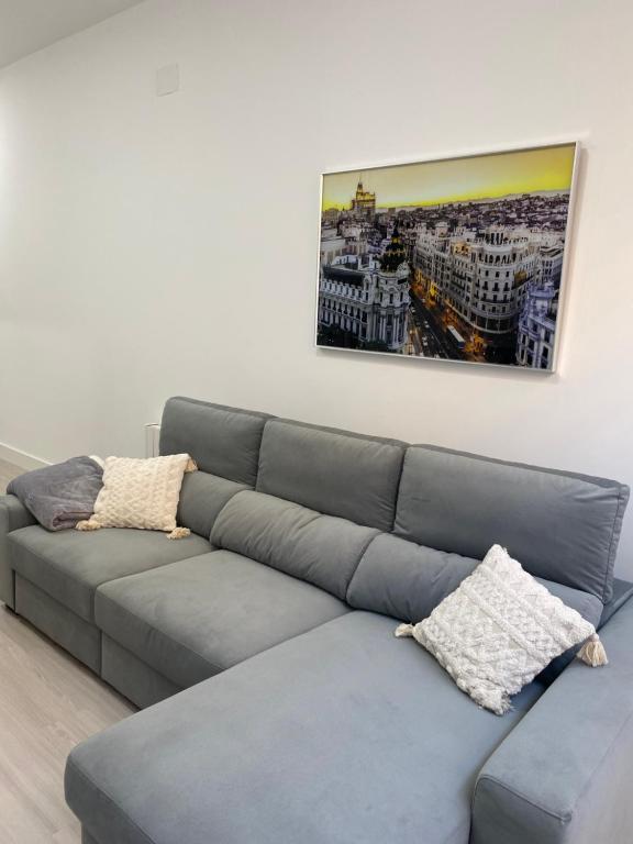 马德里Moncloa apartment, con parking的客厅里一张灰色的沙发,墙上挂着一幅画