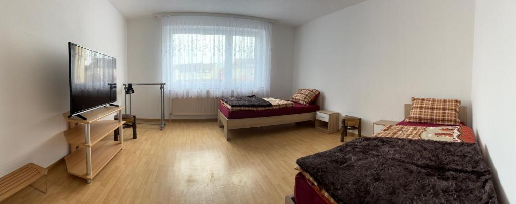 普福尔茨海姆Ferienwohnung Grimm的客房设有两张床、一台电视和一张沙发。