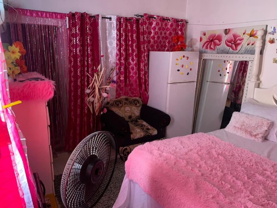 Old Harbourapolts的粉红色的卧室配有床和冰箱
