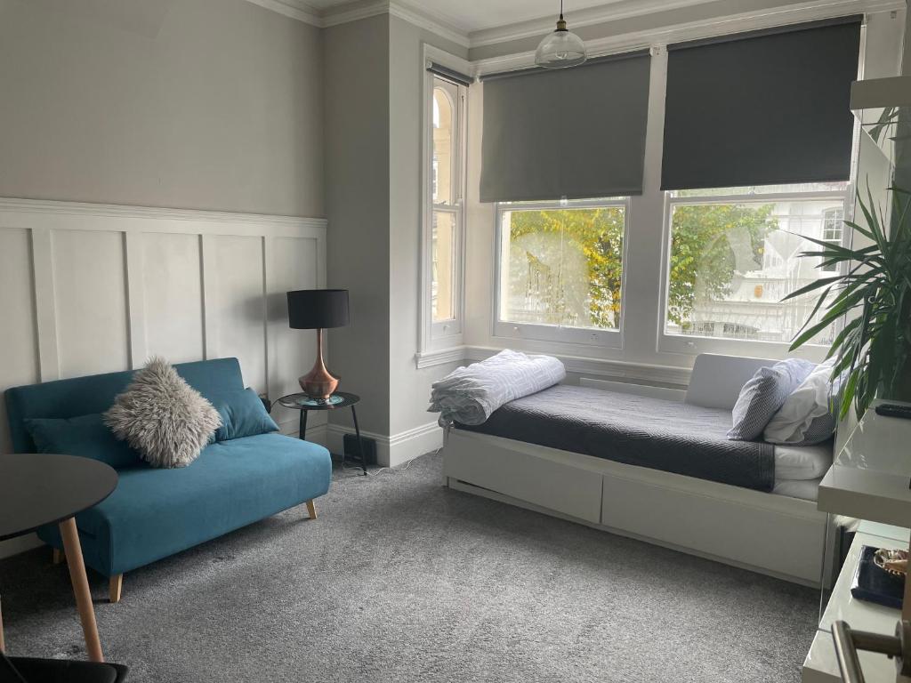 布莱顿霍夫Lancaster Entire Studio的一间卧室配有一张床、一张沙发和两个窗户。