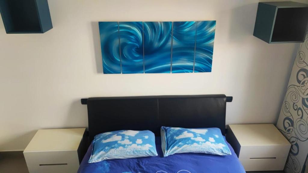 罗马Barzo Apartment的卧室配有一张床,墙上挂有绘画作品