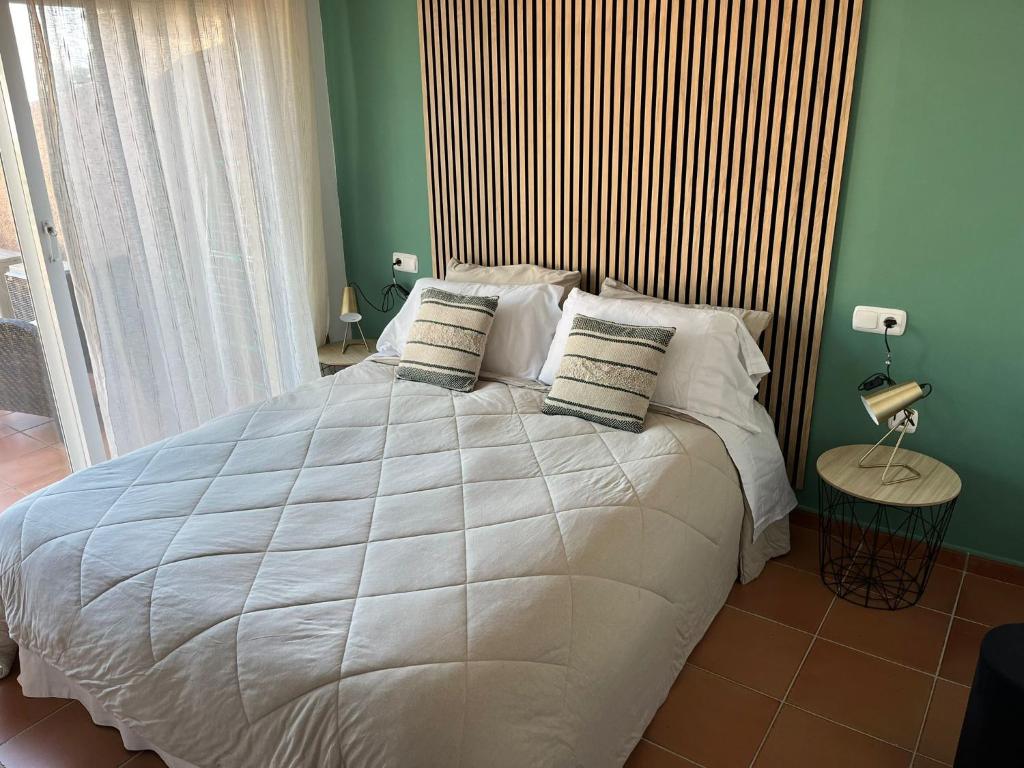 阿尔加德萨Apto. Residencial La Alcaidesa的卧室配有一张白色大床和木制床头板